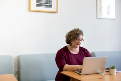 FAQ research Woman researching dental FAQs on her laptop at home