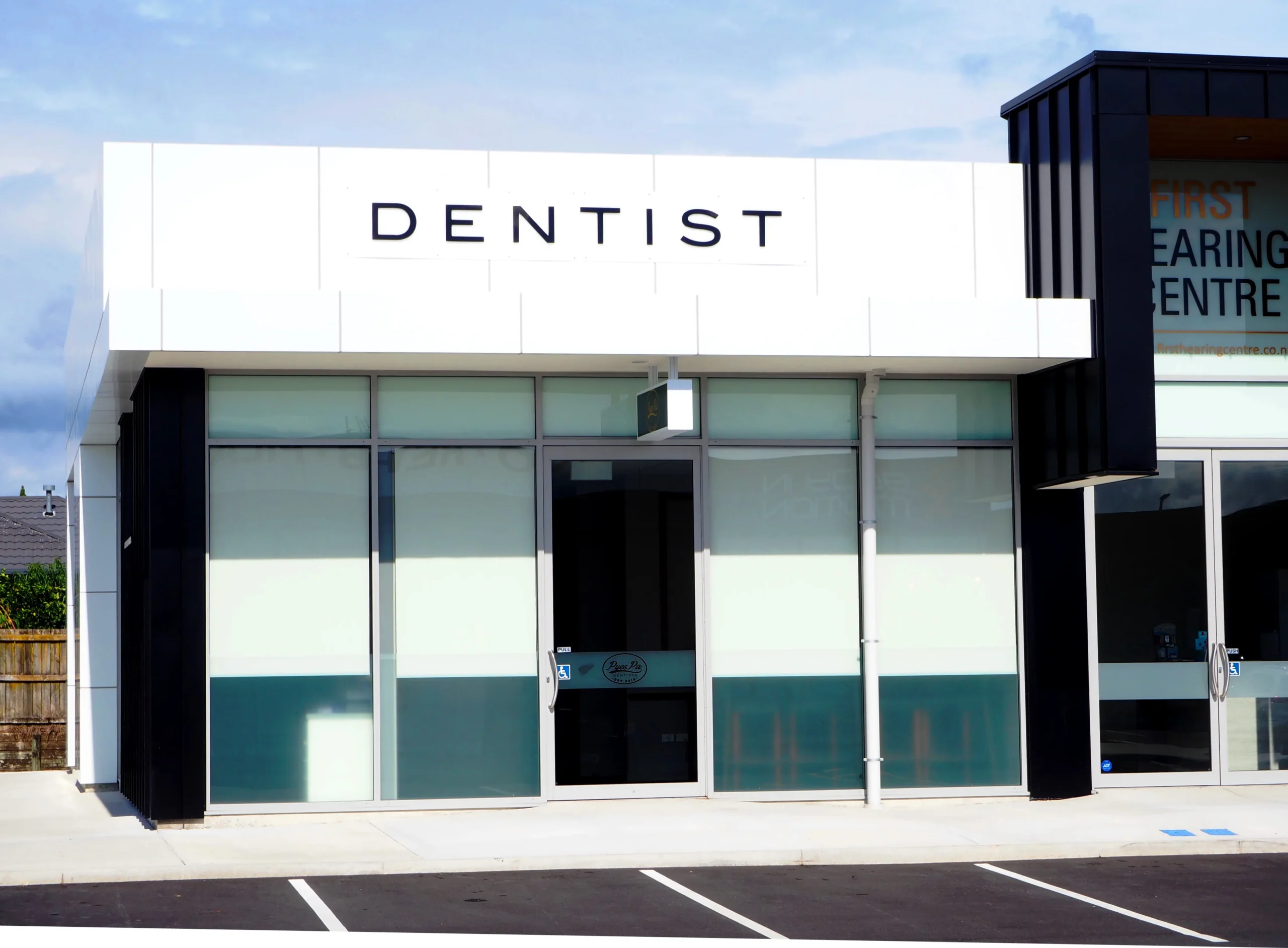 Modern dental office exterior with large windows and signage