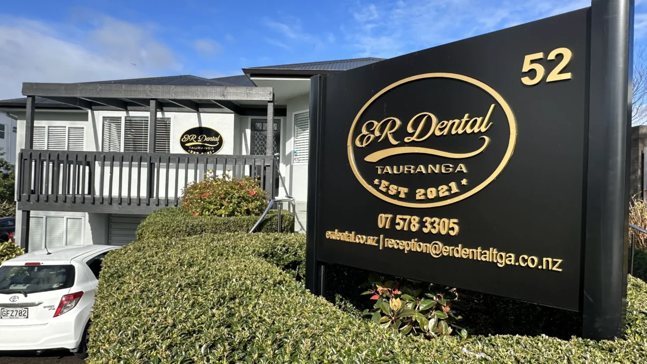 Dental clinic building with a sign displaying contact information in Tauranga