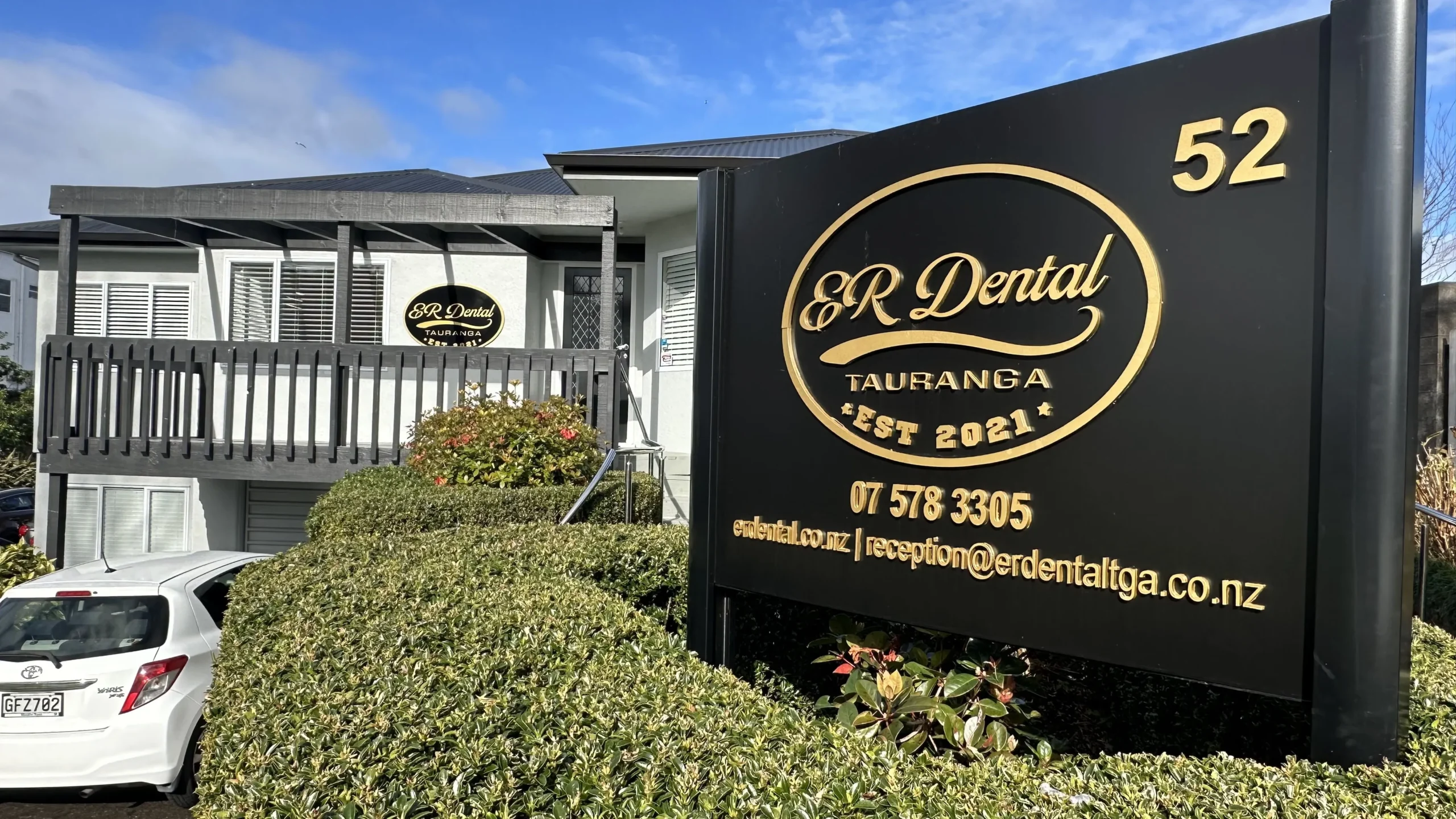 Dental clinic building with a sign displaying contact information in Tauranga